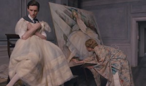 Einar holding a dress as his wife, Gerda (Alicia Vikander), draws him as a woman. Holding the dress, however, awakens Lili.